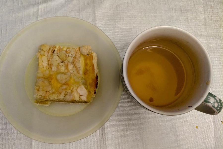 Apfelkuchen auf einem Teller und Teetasse mit Fenchel-Kümmel-Anistee